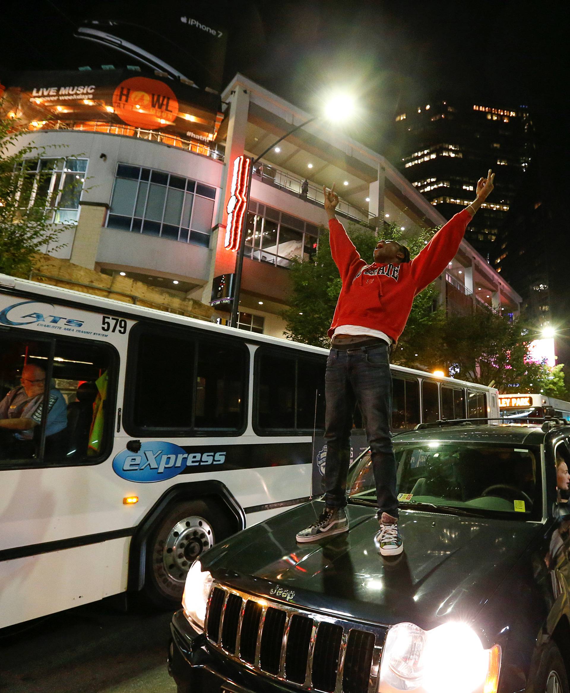 A man stands on a car in uptown Charlotte, NC to protest the police shooting of Keith Scott, in Charlotte, North Carolina