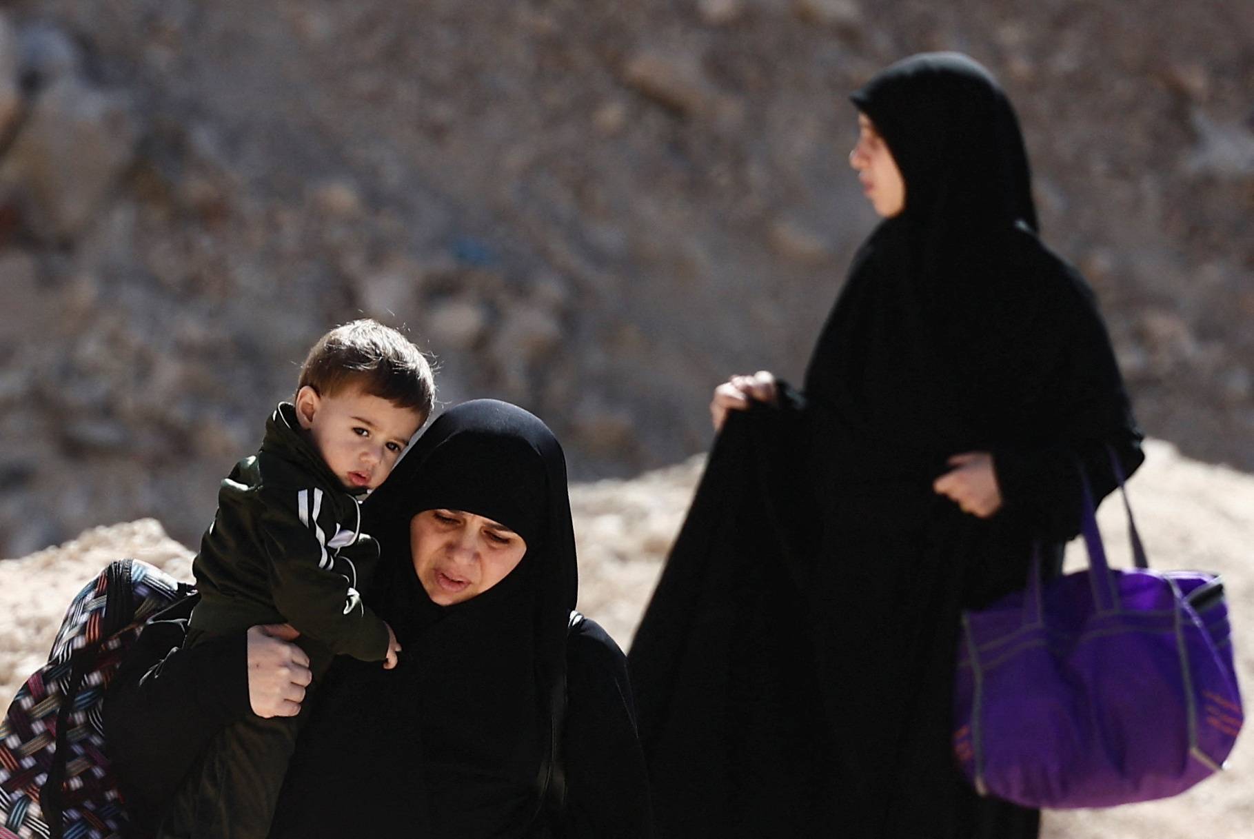 People cross from Lebanon into Syria as they flee the ongoing hostilities between Hezbollah and Israeli forces