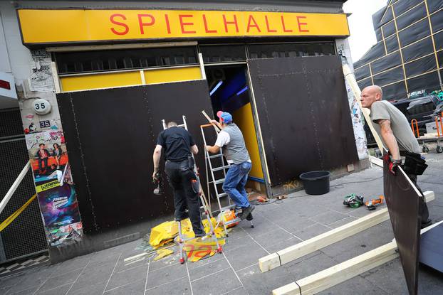 Workers put plates on shop windows to protect from eventual damage during demonstrations at the G20 summit in Hamburg