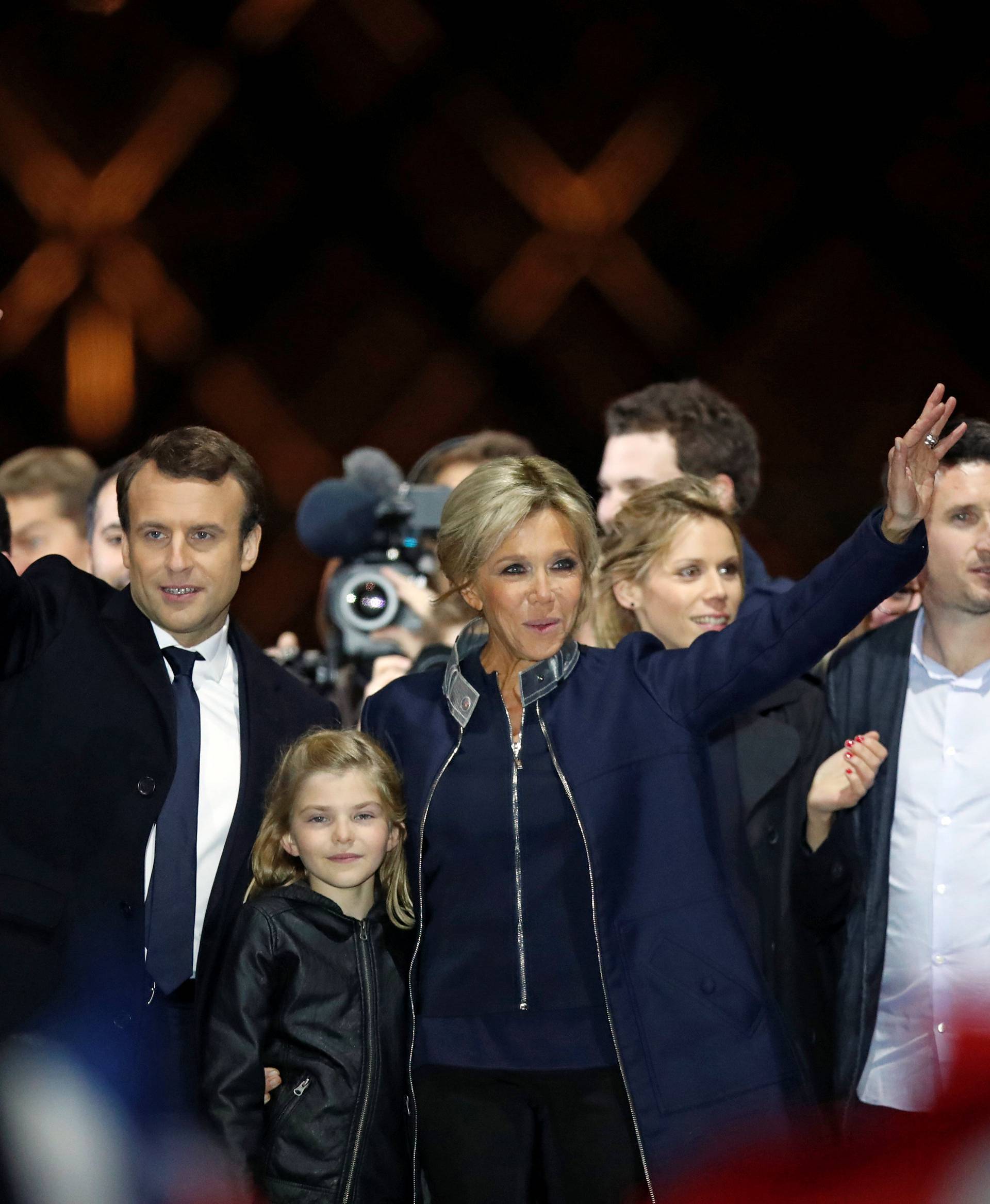 French President elect Emmanuel Macron and his wife Brigitte Trogneux celebrate on the stage at his victory rally near the Louvre in Paris