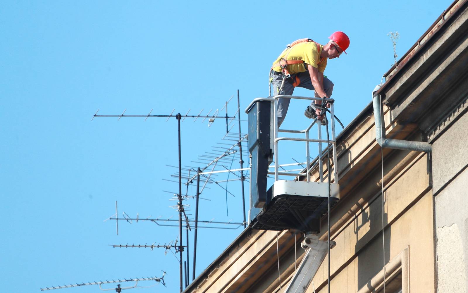 Zagreb: Radnik u košari dizalice sanira krov zgrade