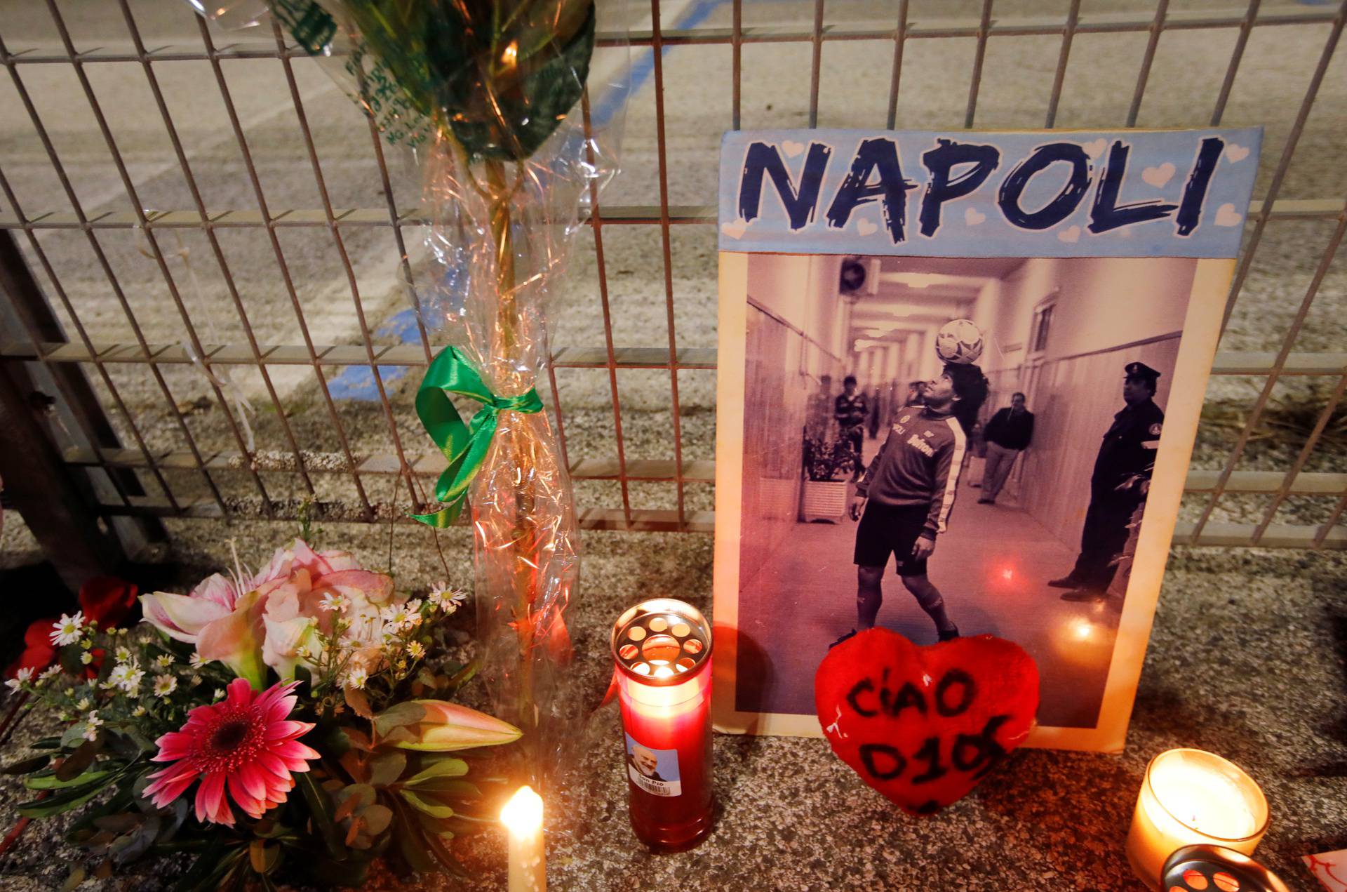 People gather to mourn the death of Argentine soccer legend Diego Maradona outside San Paolo stadium in Naples