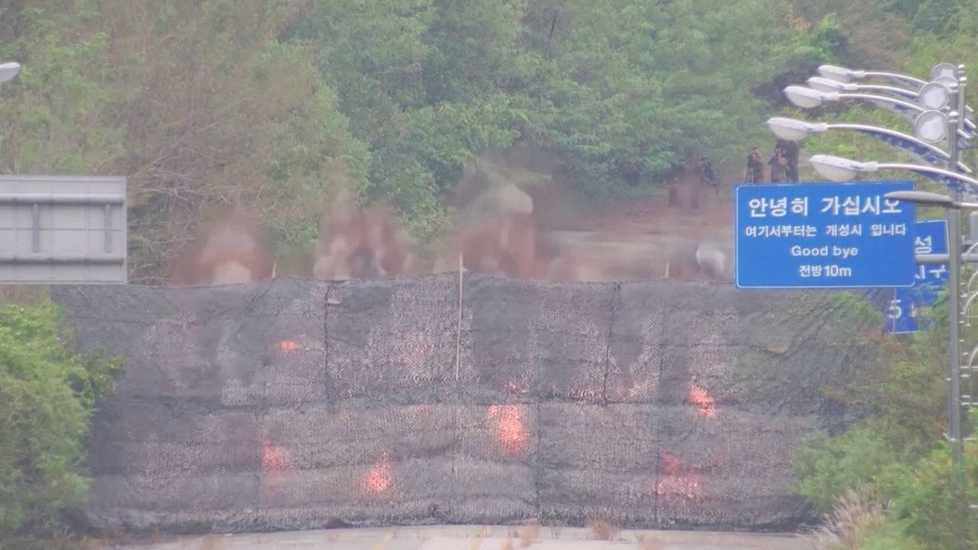 Fire and smoke after North Korea blows up sections of inter-Korean roads on its side of the border between the two Koreas, as seen from the South Korean side