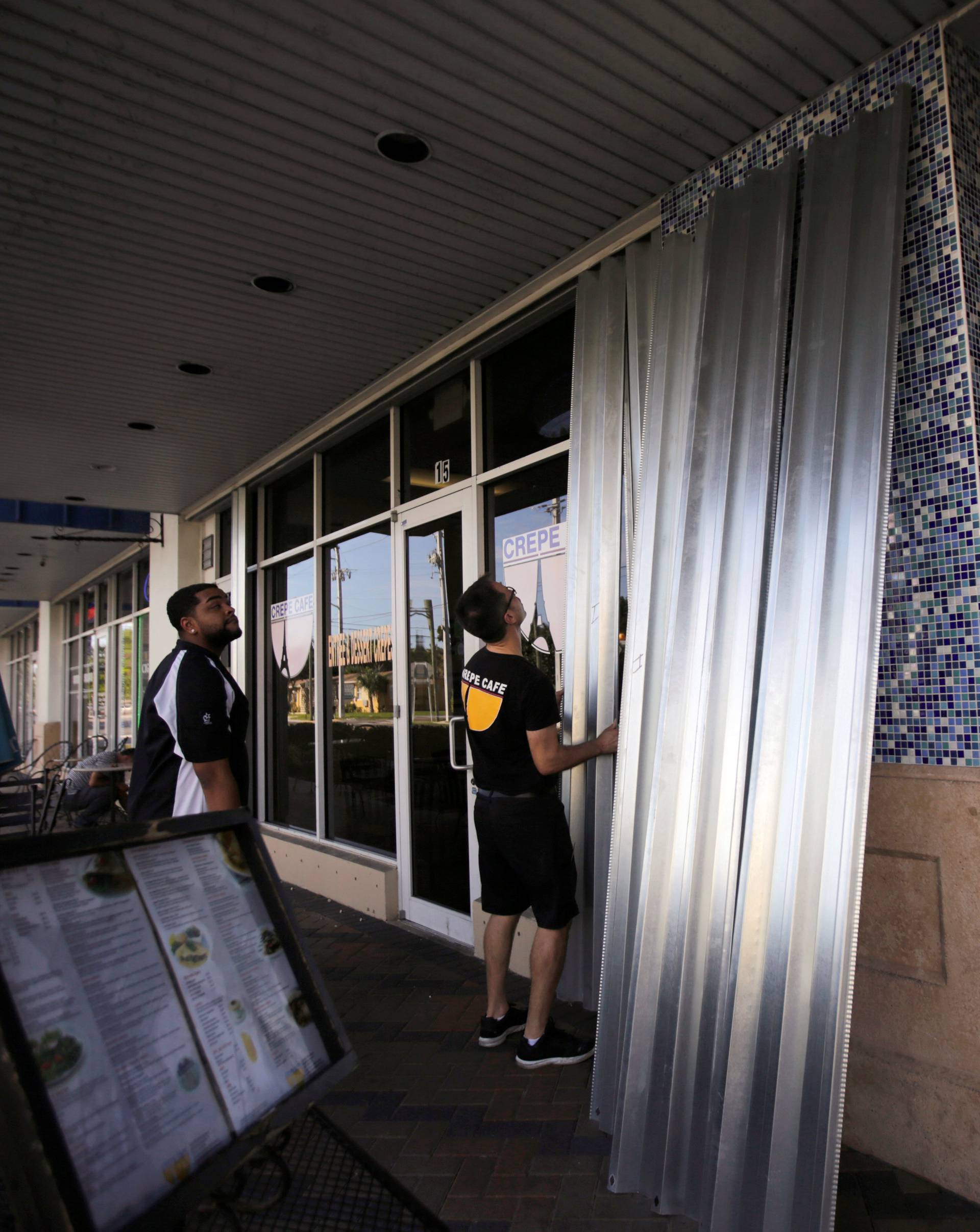 Employees cover the doors and windows at a restaurant in Deerfield beach near Coral Springs in anticipation of Hurricane Matthew in Florida