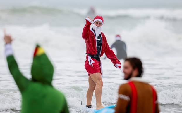 Surfing Santas take to the waves at the annual Christmas Eve event in Cocoa Beach
