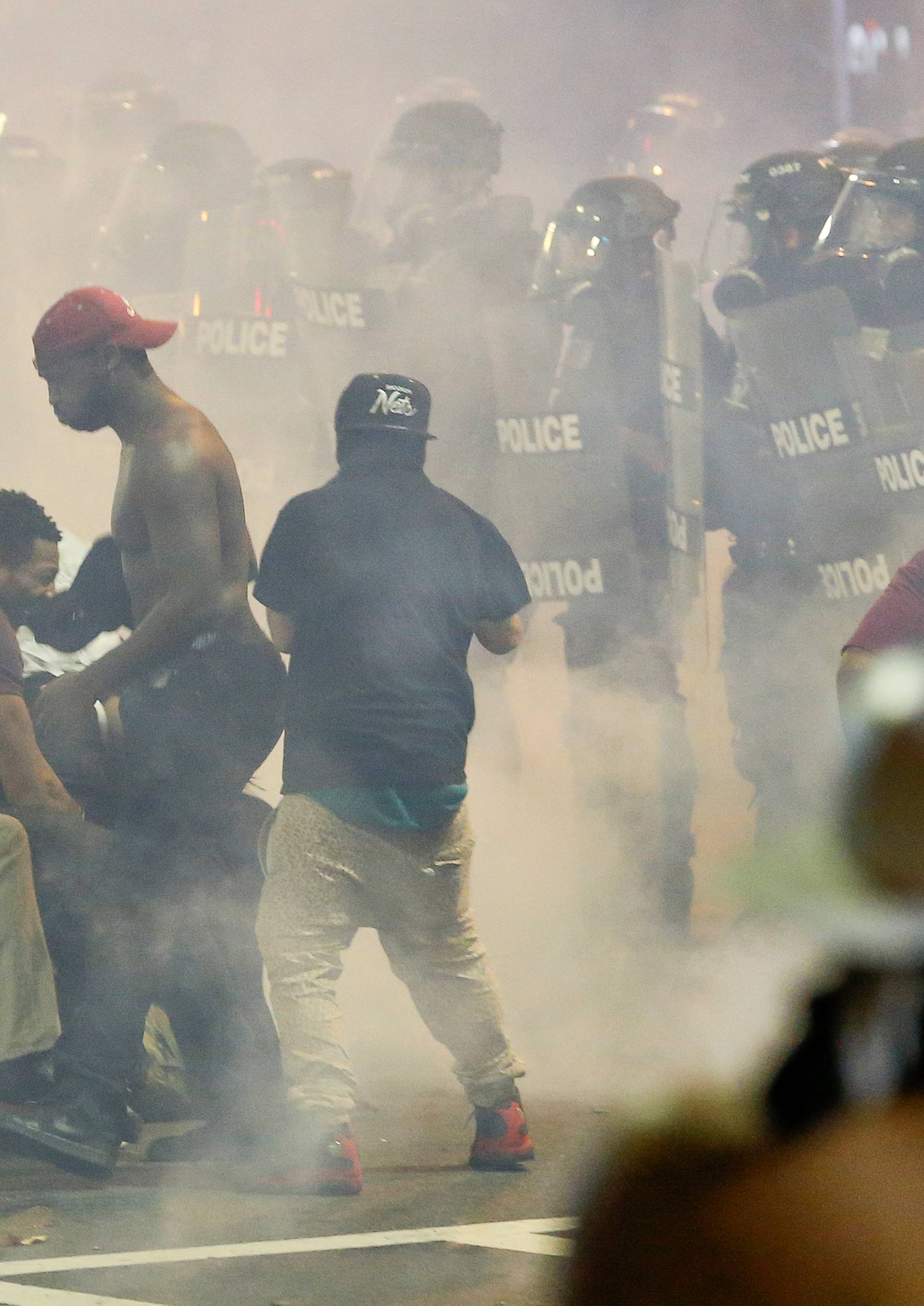 People maneuver amongst tear gas in uptown Charlotte, NC during a protest of the police shooting of Keith Scott, in Charlotte