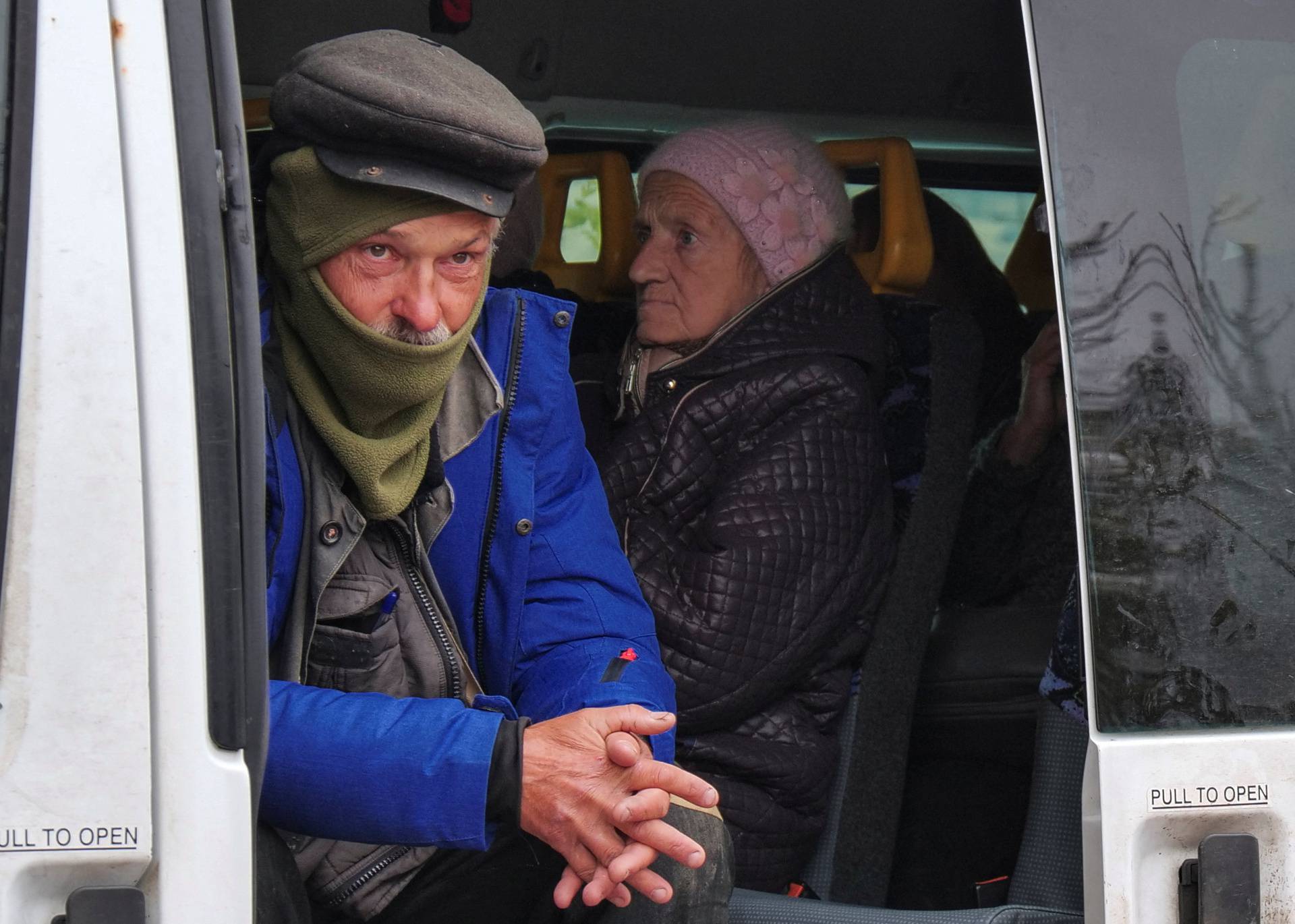 Local man looks out of a volunteer's bus as he waits for an evacuation from the frontline town of Kupiansk