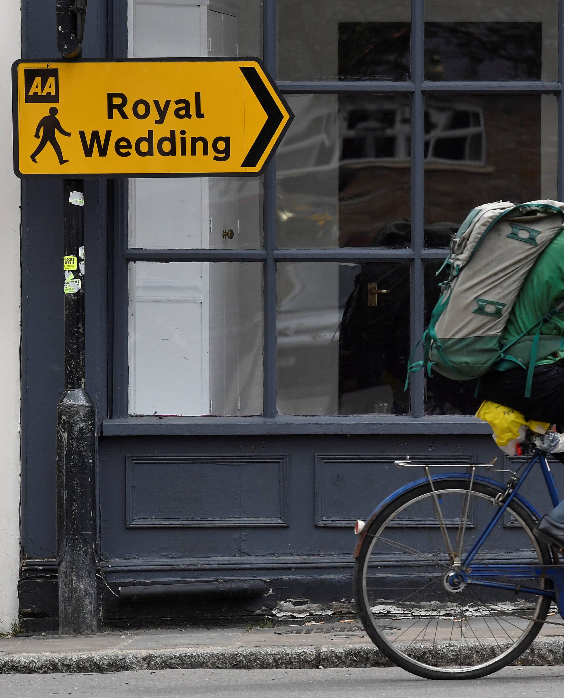 A man cycles past direction signs placed for the forthcoming wedding of Britain's Prince Harry and his fiancee Meghan Markle in Windsor, Britain