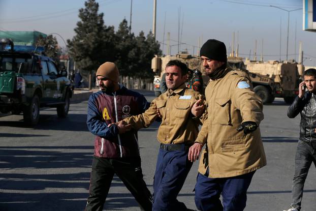 A wounded security guard receives help after being rescued from Kabul