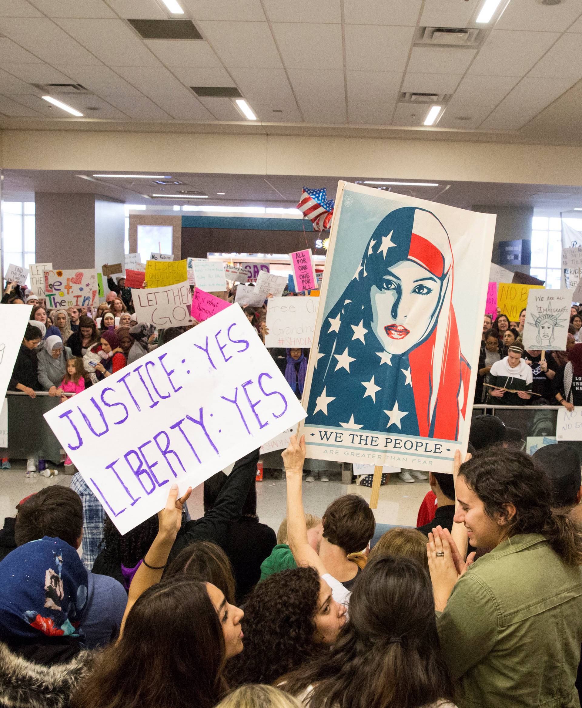 People gather to protest against the travel ban imposed by U.S. President Donald Trump's executive order, at Dallas/Fort Worth International Airport