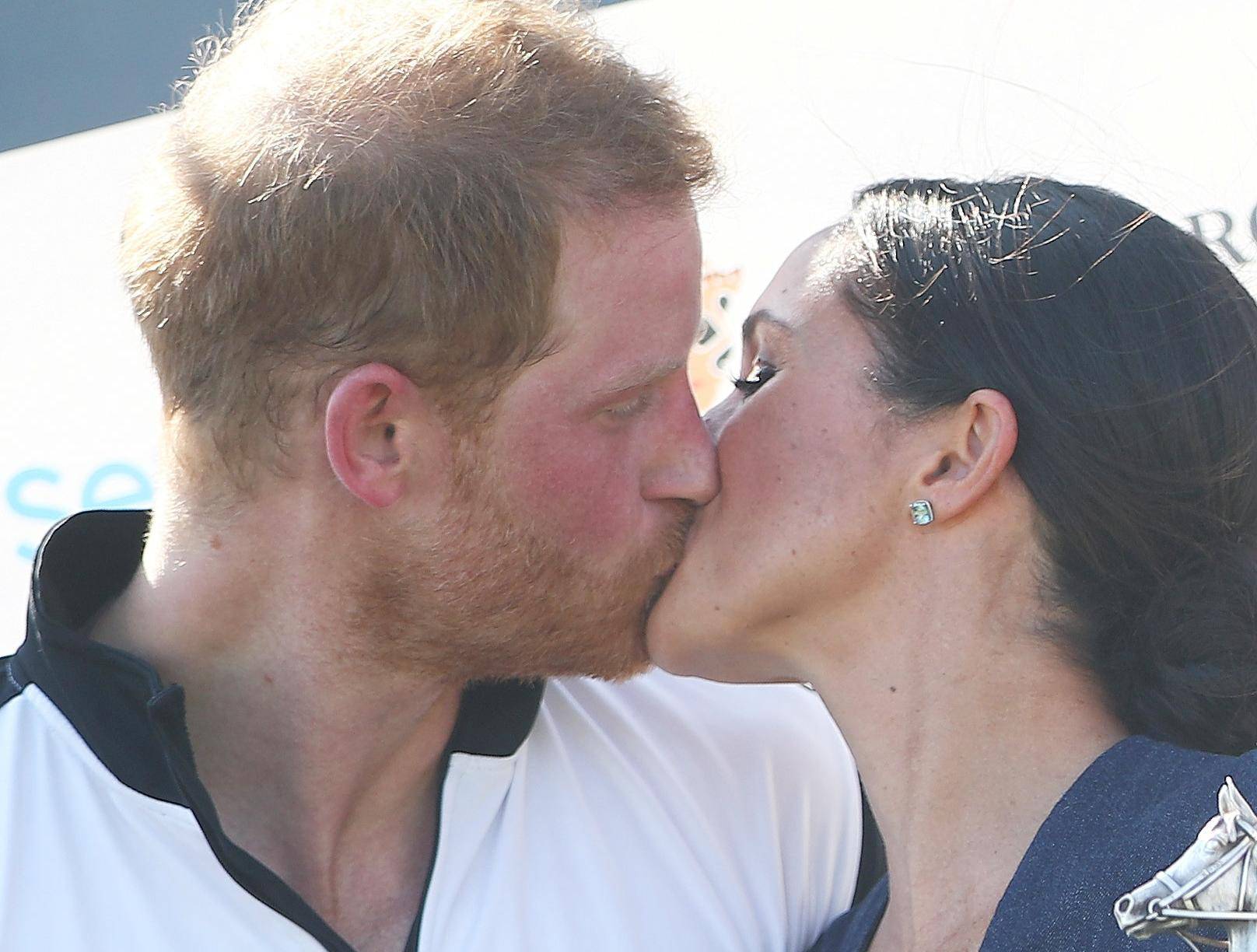Britain's Prince Harry kisses his wife Meghan the Duchess of Sussex after a charity polo match in Windsor