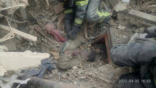 Rescuers remove a woman from debris after a military strike in Rubizhne