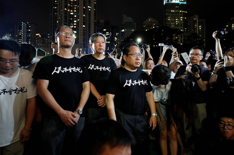 Pro-democracy activists Richard Tsoi Yiu Cheong, Lee Cheuk-yan, Albert Ho Chun-Yan pay tribute to those who died during a candlelight vigil at Victoria Park in Hong Kong