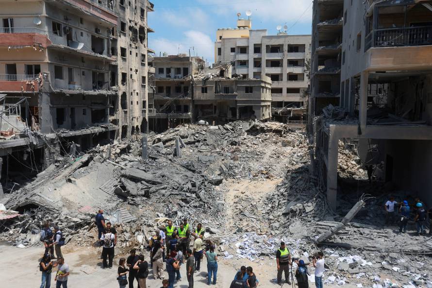 People inspect the damage in the aftermath of an Israeli strike, in Tyre