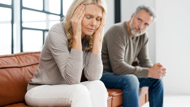 Frustrated senior couple at home, sitting on the couch and keep silent in a quarrel