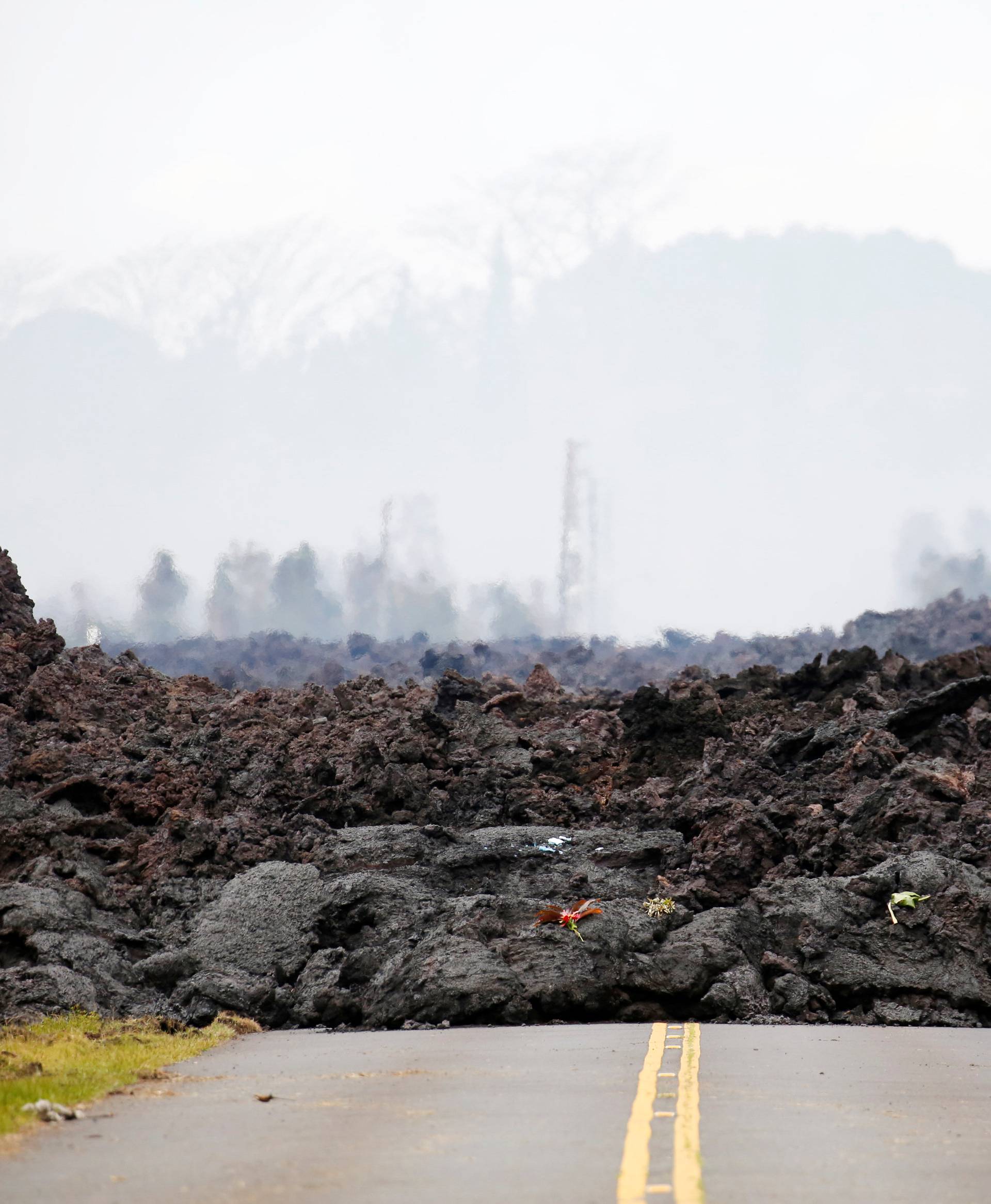 A lava flow covers a road in the Leilani Estates subdivision during ongoing eruptions of the Kilauea Volcano