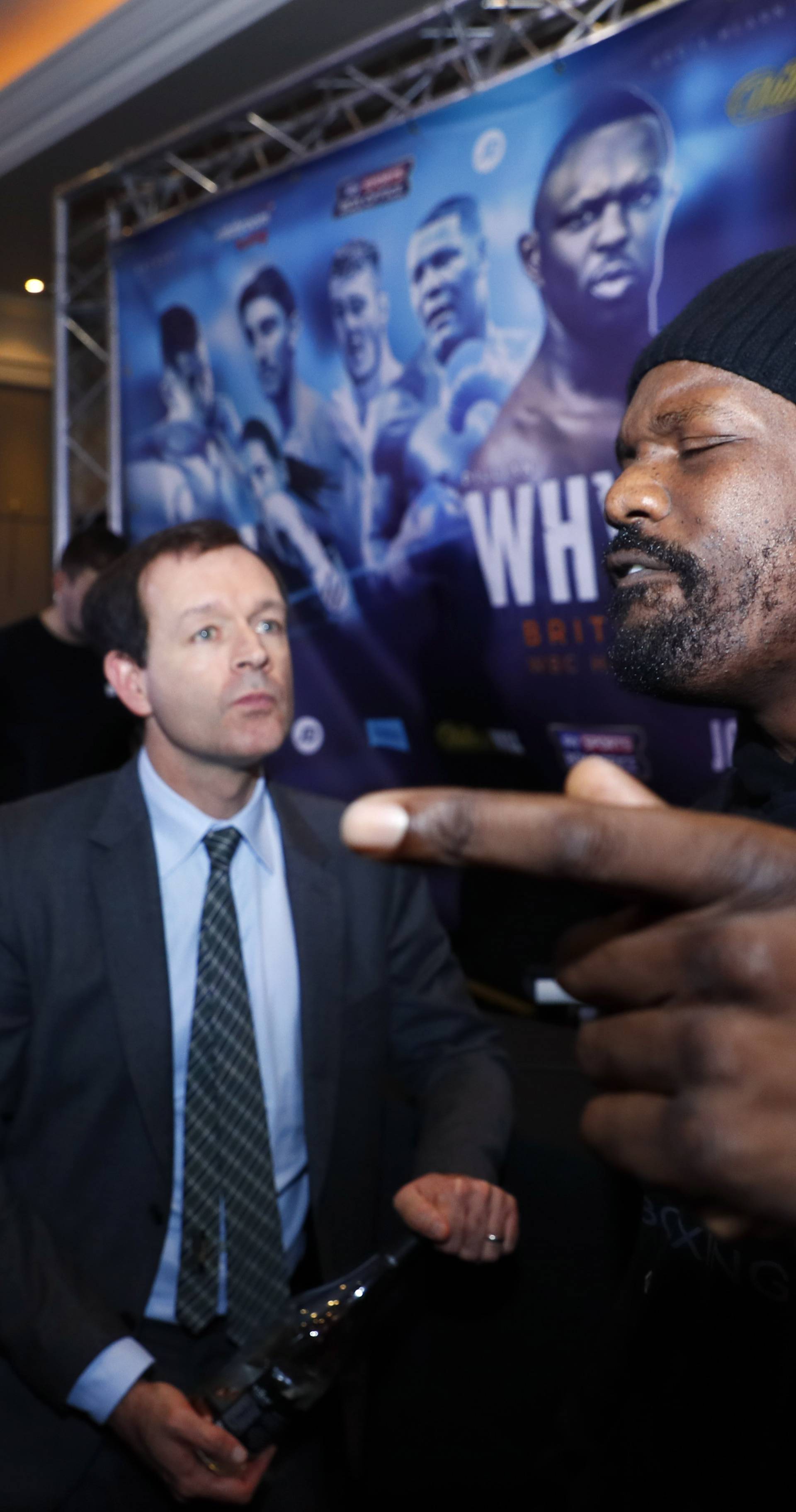 Sky Sports' Adam Smith and promoter Kalle Sauerland look on as Dereck Chisora gestures during the press conference