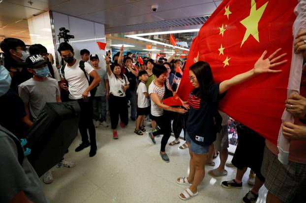 A Pro-China demonstrator stands in front a Chinese national flag during an argument with anti-government protesters at Amoy Plaza shopping mall in Kowloon Bay, Hong Kong