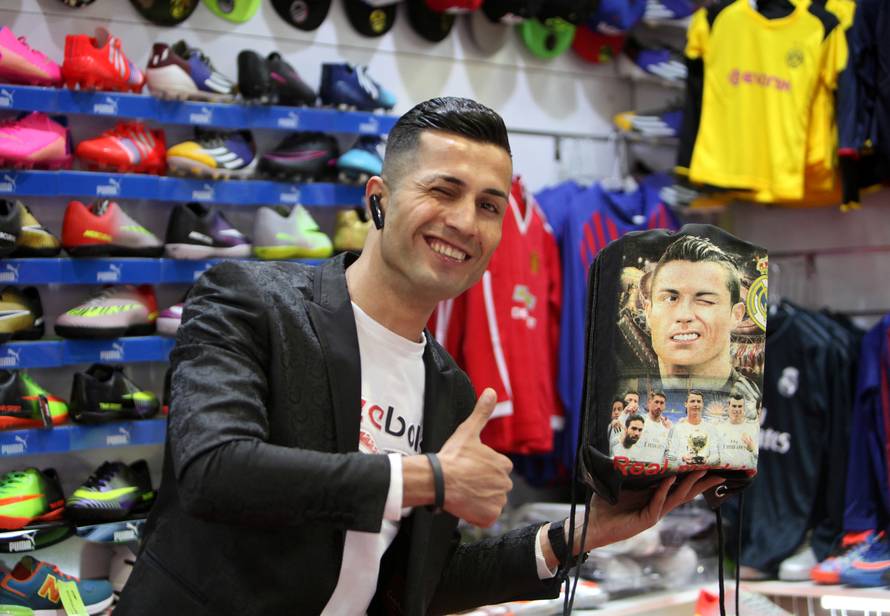 Biwar Abdullah, 25, an Iraqi Kurdish local footballer, who looks like the football player Cristiano Ronaldo, pose for a pictures at a sportswear shop in the district of Soran, northeast of Erbil