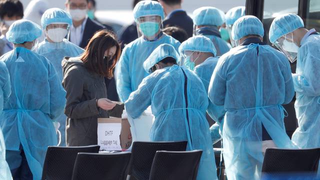 Passengers wearing masks leave cruise ship Diamond Princess at Daikoku Pier Cruise Terminal in Yokohama