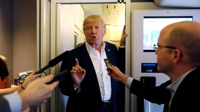 U.S. President Donald Trump speaks with reporters aboard Air Force One on his way to a "Make America Great Again" rally at Orlando Melbourne International Airport in Melbourne, Florida