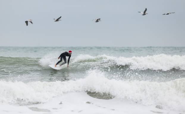 Surfing Santas take to the waves at the annual Christmas Eve event in Cocoa Beach