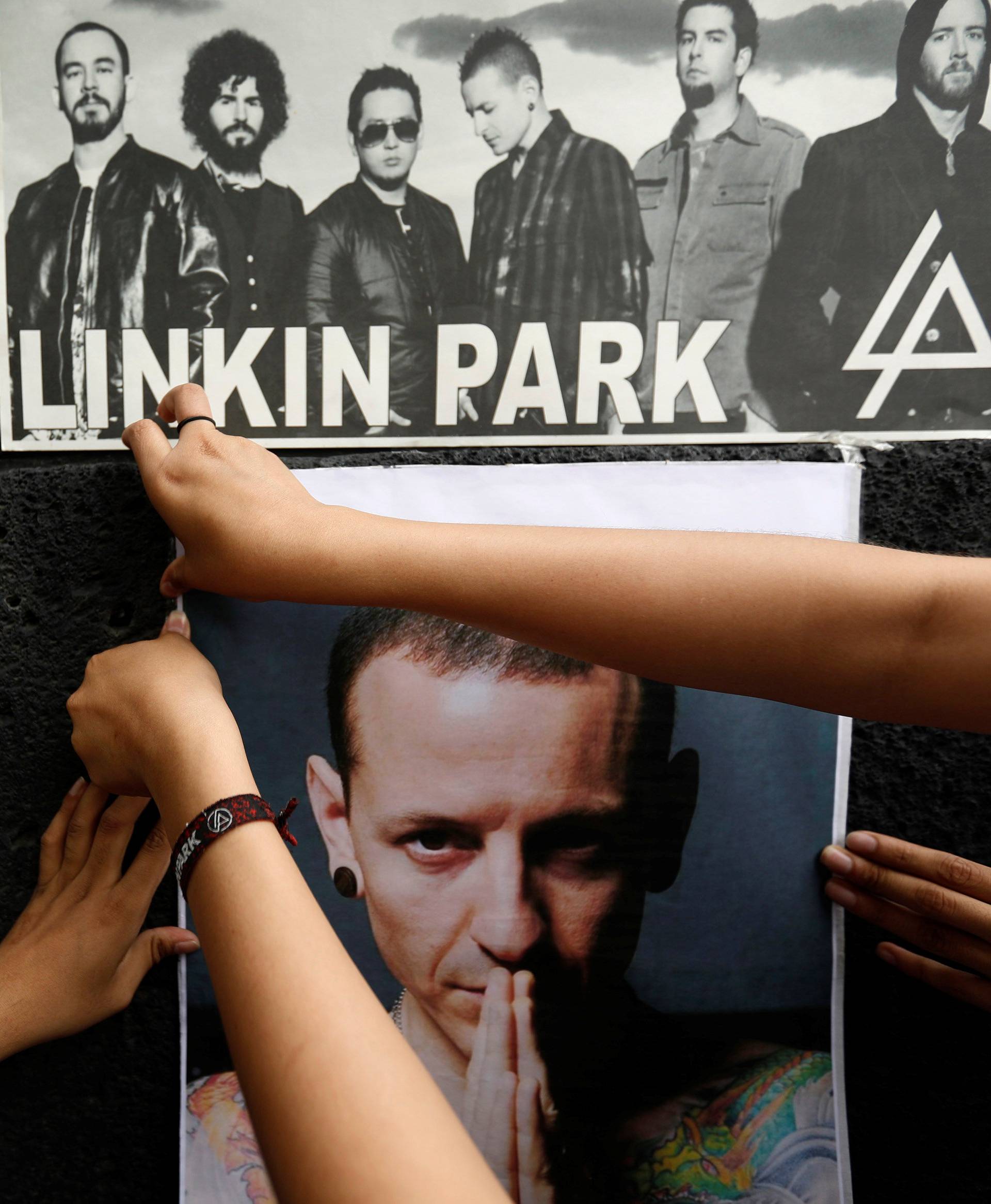 Fans stick posters as they gather at Revolucion monument to pay tribute to Linkin Park frontman Bennington in Mexico City