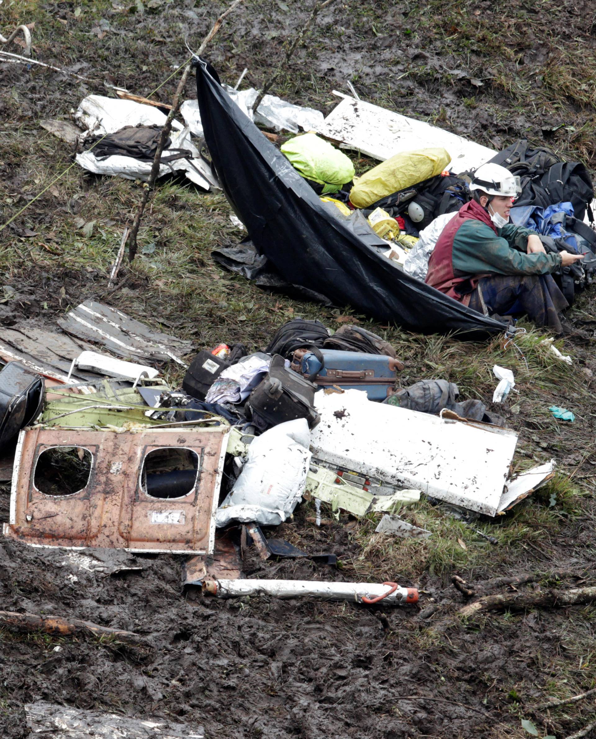 A rescue worker sits near the wreckage of a plane that crashed into the Colombian jungle with Brazilian soccer team Chapecoense onboard near Medellin