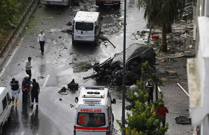 A destroyed van is pictured near a Turkish police bus which was targeted in a bomb attack in a central Istanbul district