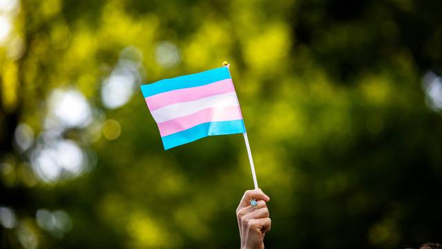 FILE PHOTO: Transgender rights activist waves a transgender flag as they protest the killings of transgender women this year, at a rally in Washington Square Park