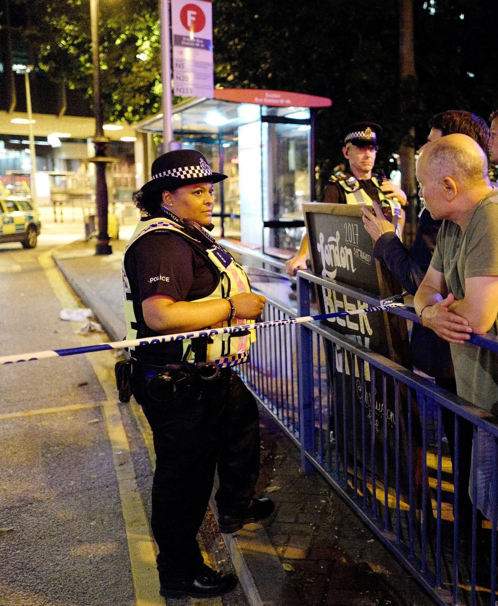 Police and commuters are seen outside Euston Station after police evacuated the area following a security alert in London