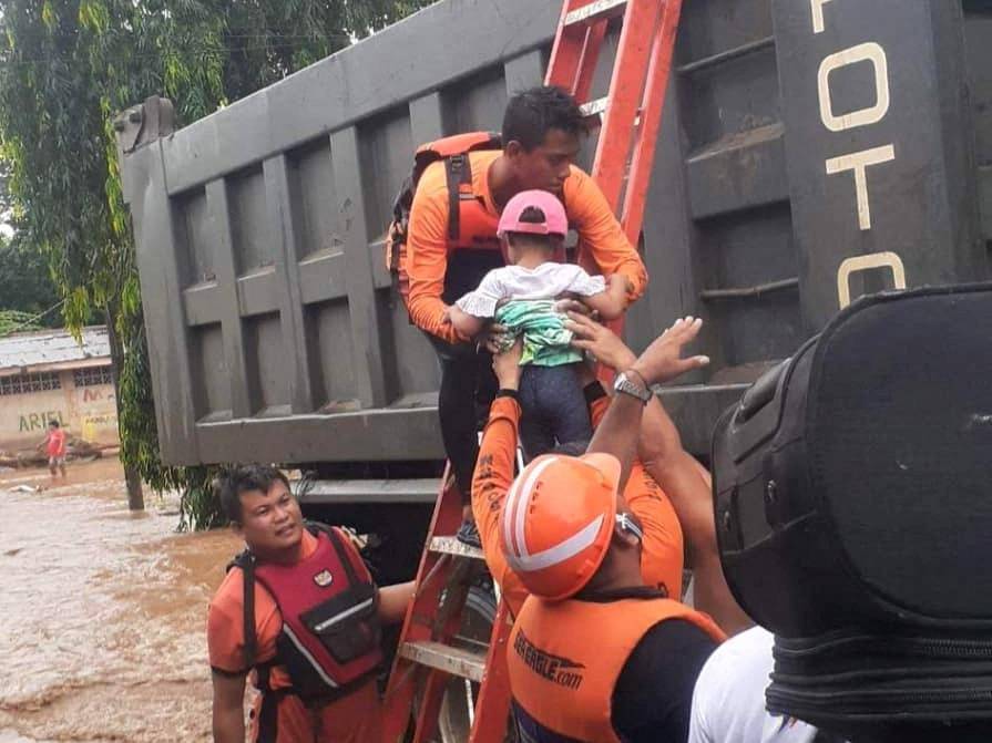 Rescue workers help people affected by floods in Philippines