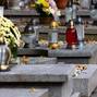Candles and flowers on graves in the cemetery during the All Saint's Day. Taken during the day, natual light.