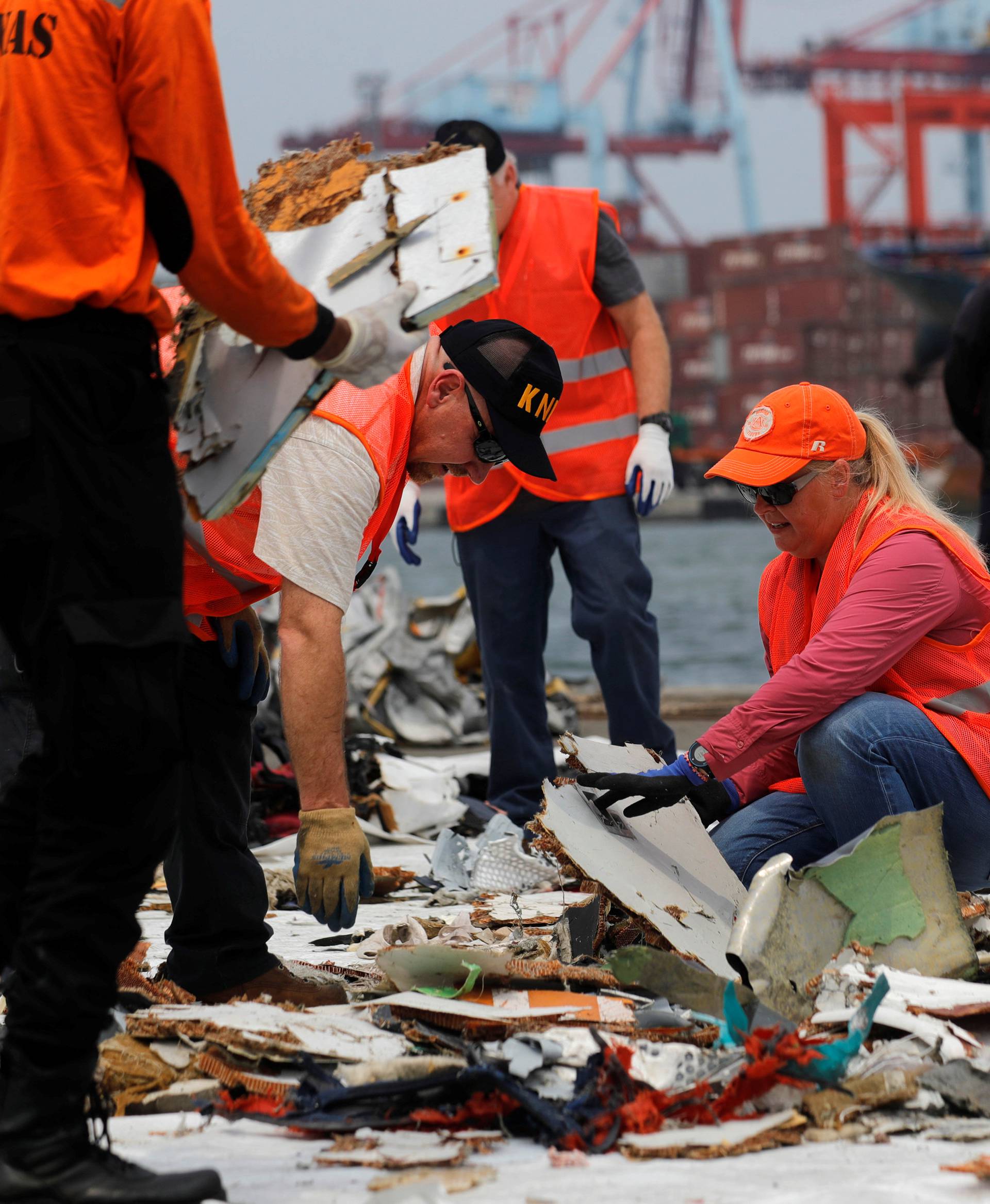 Personnel from National Transportation Safety Board examine debris from Lion Air flight JT610 at Tanjung Priok port in Jakarta