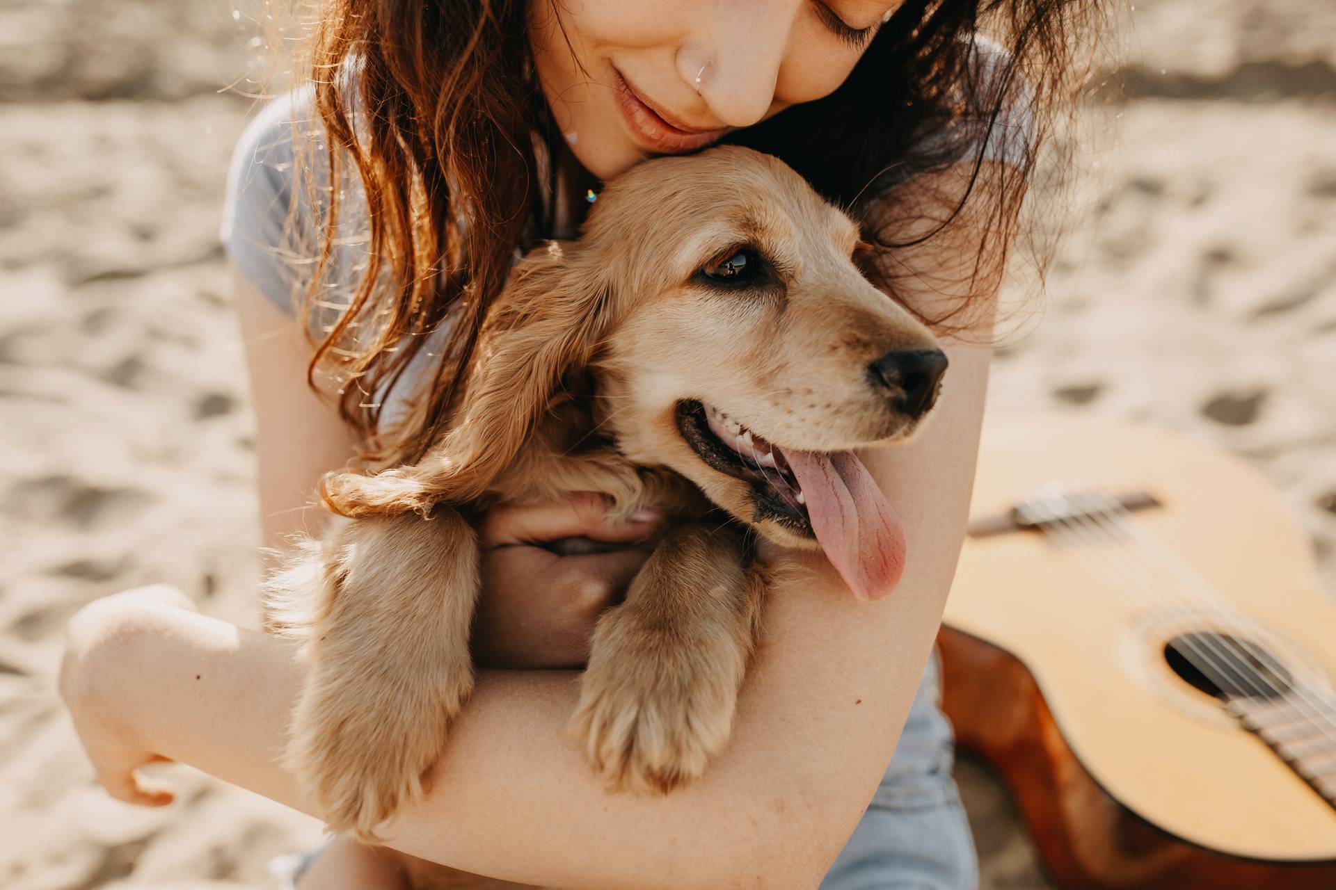 Young,Woman,Sitting,On,The,Sand,On,A,Beach,,Hugging