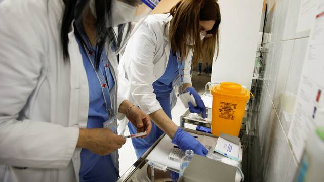 Healthcare workers prepare to administer a dose of the Sputnik V coronavirus disease (COVID-19) vaccine to their colleagues in Podgorica