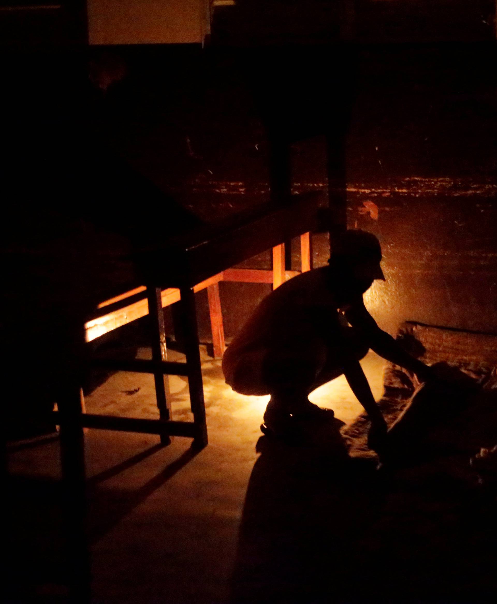 A woman improvises a bed at the shelter set up in the Lycee Philippe Guerrier ahead of Hurricane Matthew in Les Cayes, Haiti