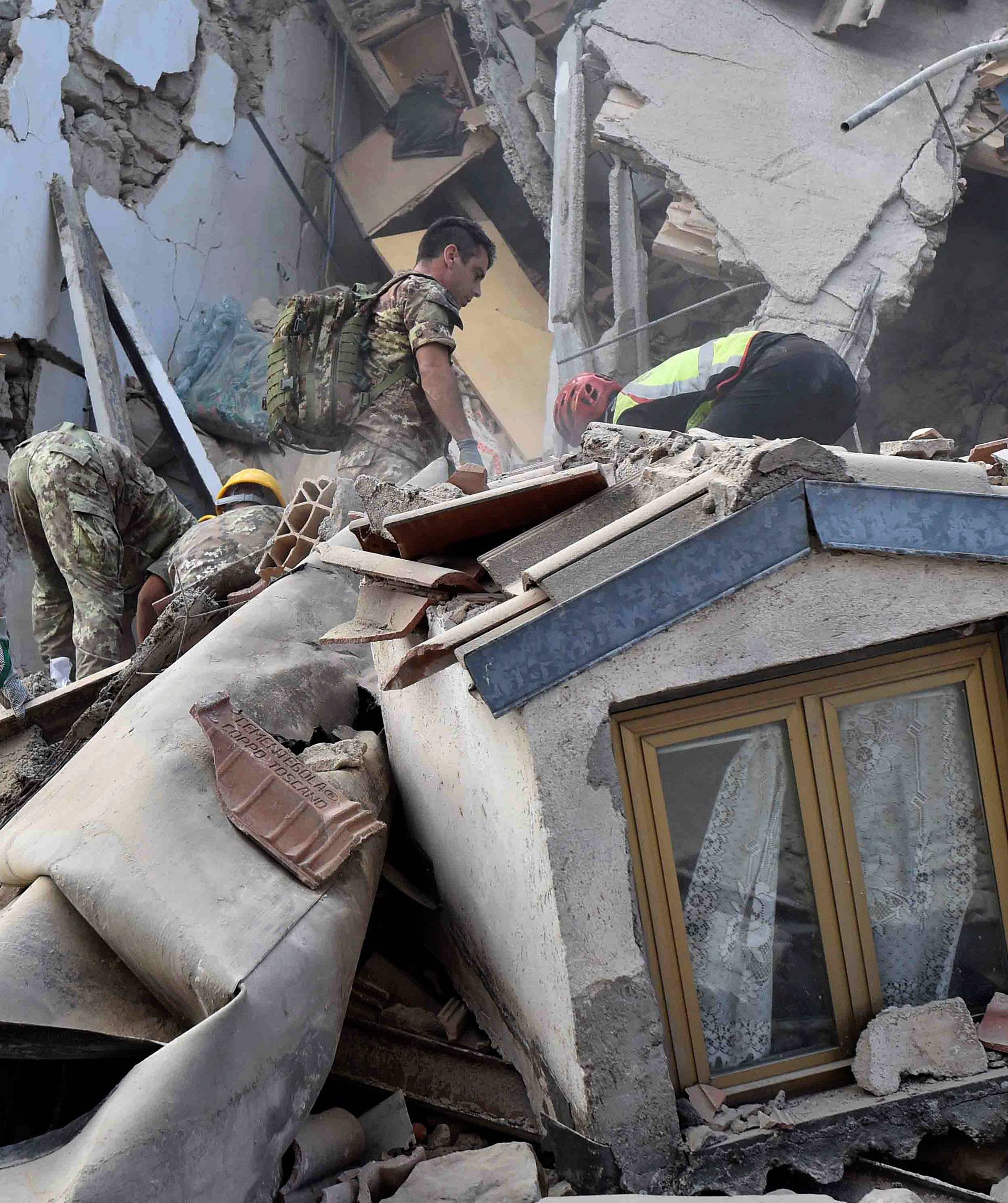 Rescuers work at a collapsed building following an earthquake in Amatrice