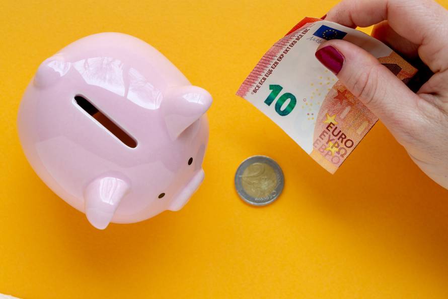 woman putting money in a piggy bank