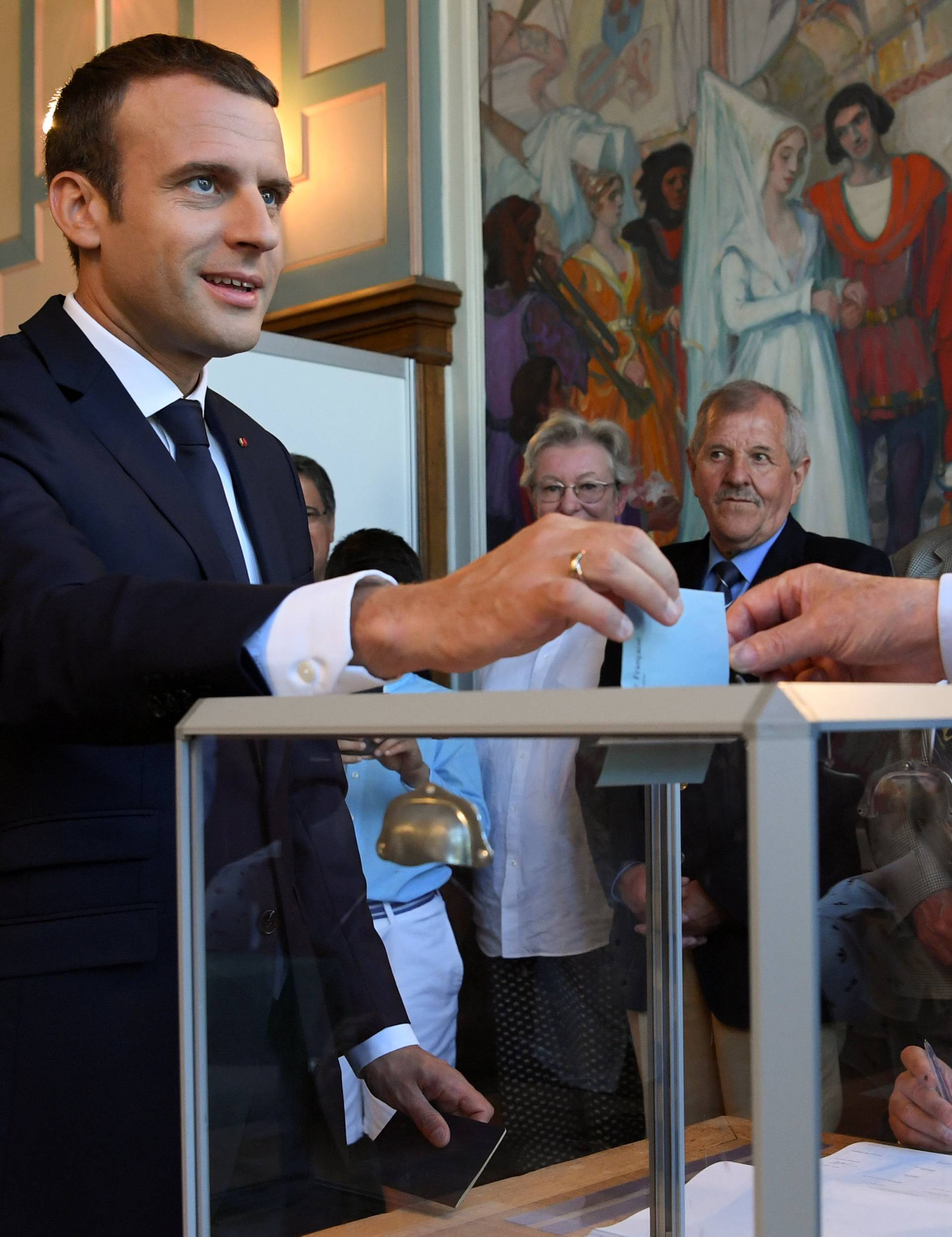French President Emmanuel Macron casts his ballot as he votes at a polling station in the second round parliamentary elections in Le Touquet