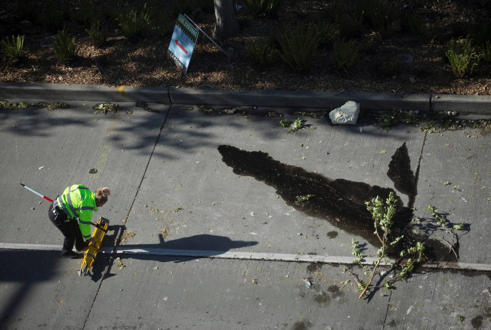 A crime scene investigator works near where part of a construction crane fell onto cars on Mercer Street, killing people and injuring others, in Seattle