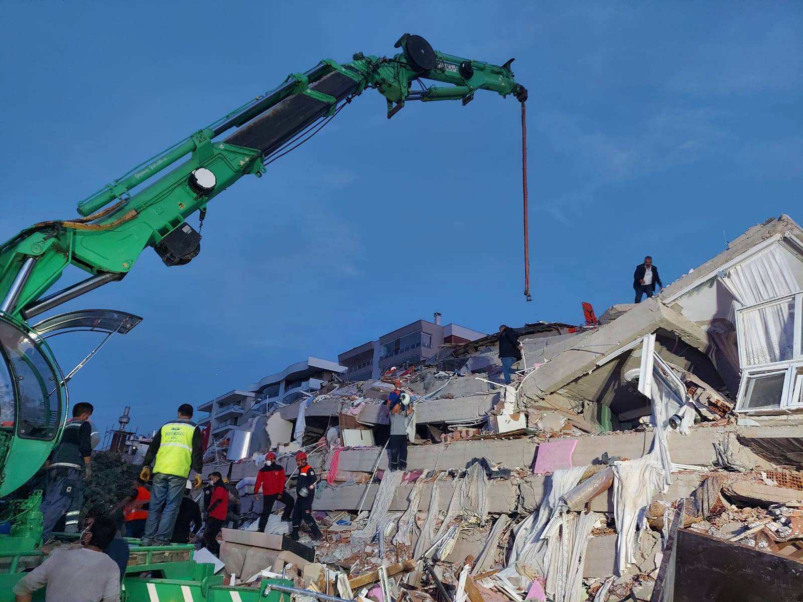 People search for survivors at a collapsed building after a strong earthquake struck the Aegean Sea where some buildings collapsed in the coastal province of Izmir