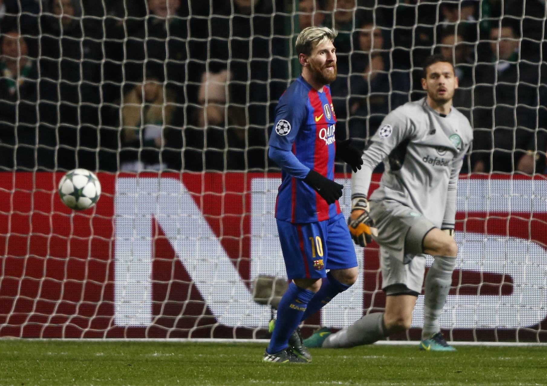 Barcelona's Lionel Messi celebrates scoring their second goal as Celtic's Craig Gordon looks dejected