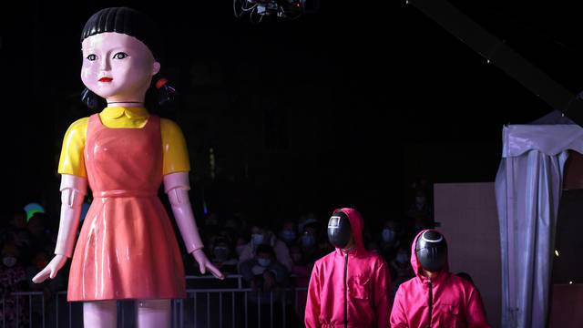 Performers wear costumes inspired by the Netflix show "Squid Game" during a Halloween event at an amusement park in Beijing