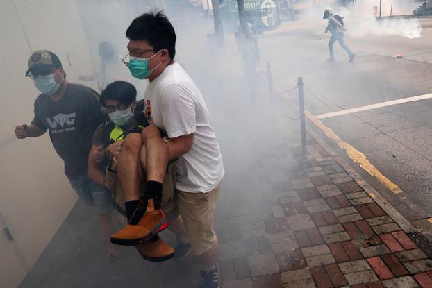 Anti-government protesters run away from tear gas during a march against Beijing’s plans to impose national security legislation in Hong Kong