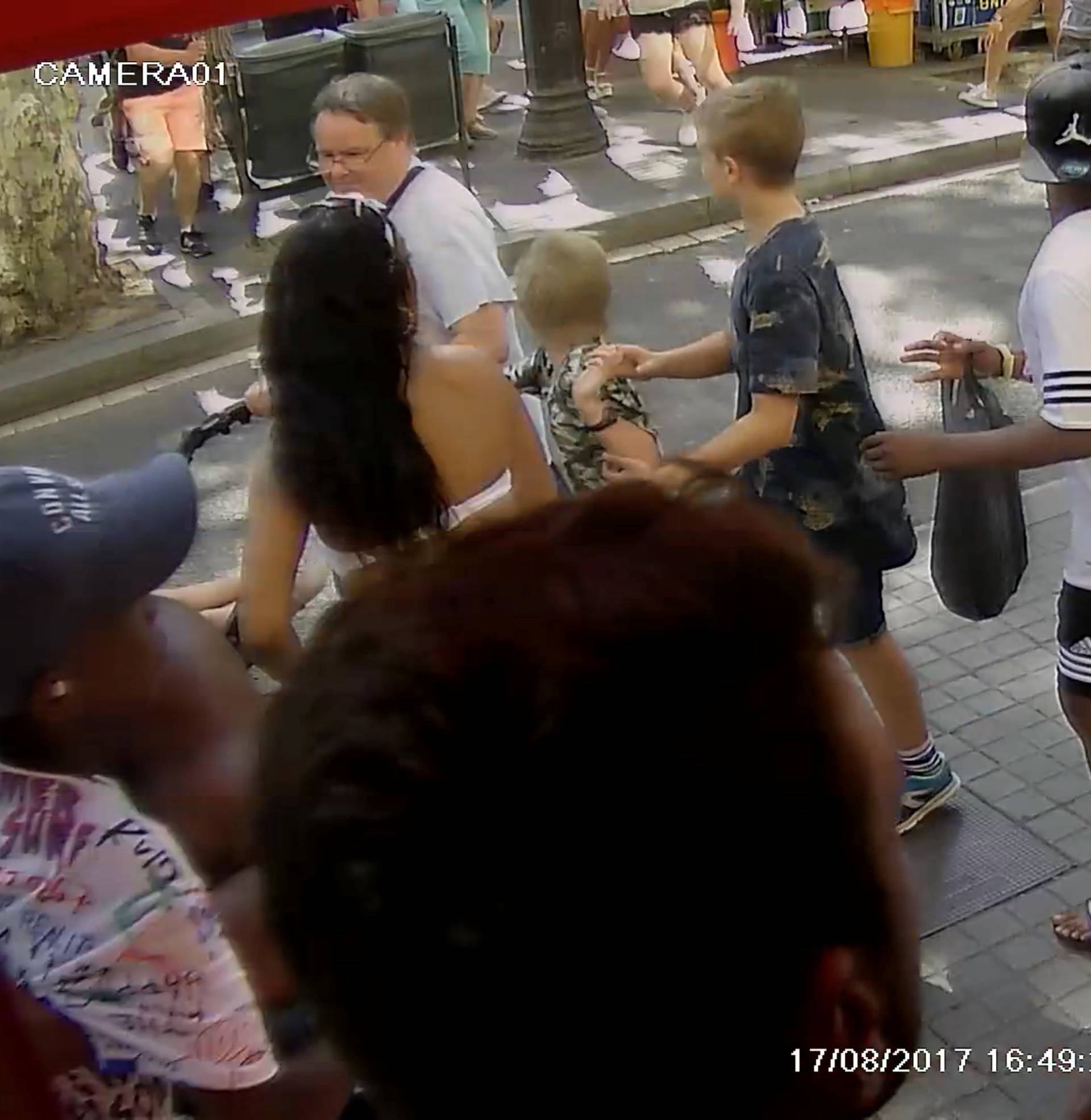 A still image from a CCTV footage shows people as they flee to safety during a van attack further down the street on La Rambla, in Barcelona