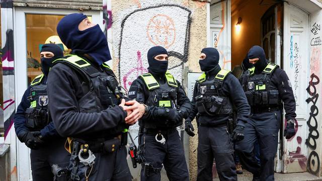 German police officers stand outside an apartment building during a raid against people supporting the Palestinian Islamist group Hamas, in Berlin