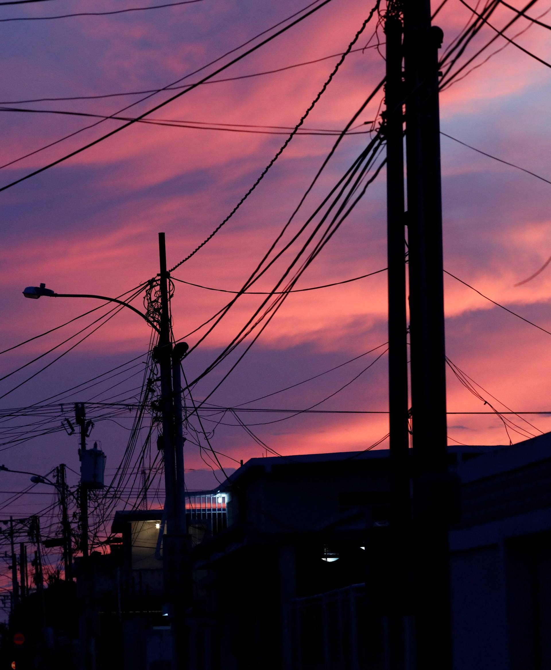 Electrical posts and power lines are seen at sunset during a blackout in Maracaibo
