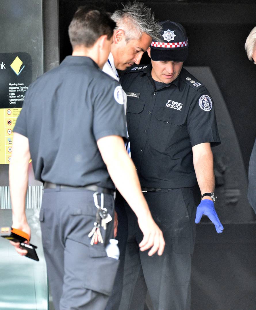 Emergency service workers are seen at a branch of the Commonwealth Bank after a fire injured customers in Melbourne