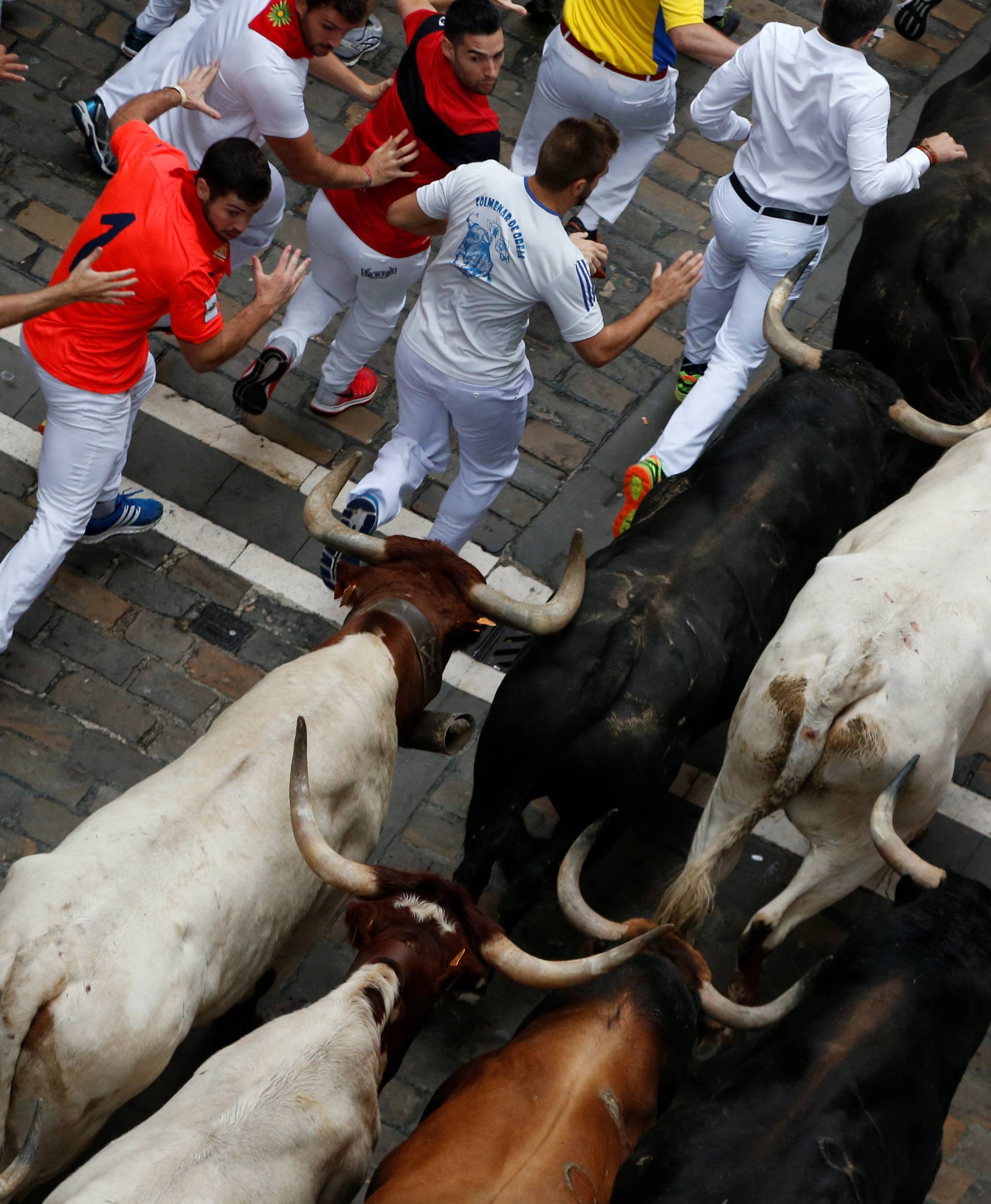Runners sprint ahead of bulls during the fourth running of the bulls at the San Fermin festival in Pamplona
